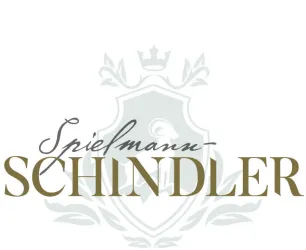 Das Bild zeigt ein stilisiertes Logo mit dem Namen "Spielmann-Schindler". Es ist elegant und hebt sich von einem dezenten Hintergrund ab.