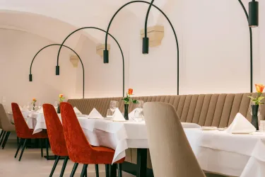 Restaurant Innenraum mit Sitzbank, roten Stühlen, schwarze schwebende Lampe über den Tischen  