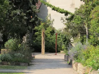 Apothekergarten mit Stein und Metallfigur (© EM Urlaubsregion Freinsheim)
