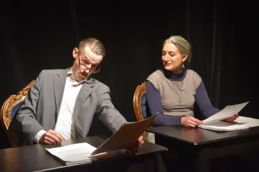 Anja Kleinhans und Birko Flemming sitzen auf zwei Stühlen  und lesen sich Liebesbriefe vor.