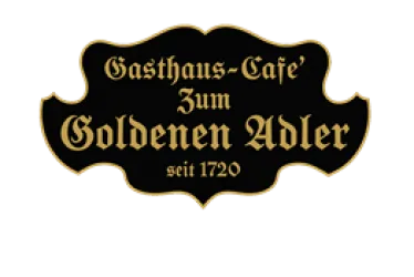 Schild mit Aufschrift Zum goldenen Adler. Schwarzer Untergrund und goldene Schrift