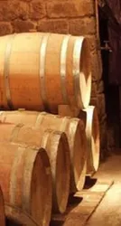 GRoße Holzfässer auf einanader gestappelt und schön beleuchtet.