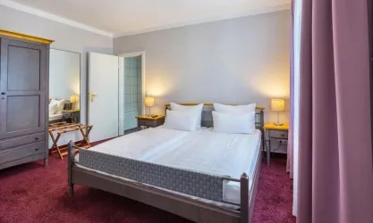 Schlafzimmer der Suite in grau und rose`Tönen gehalten