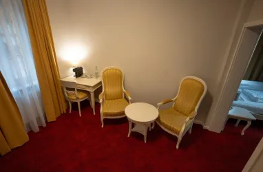 Wohnbereich mit 2 Stühlen, einem Tisch und einem Schreibtisch