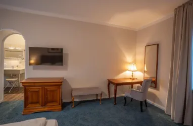 Großes Doppelzimme mit Fernseher und Blick ins Badezimmer 