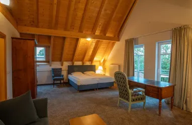 Großes Doppelzimmer mit Doppelbett, Schreibtisch mit Blick in den Garten