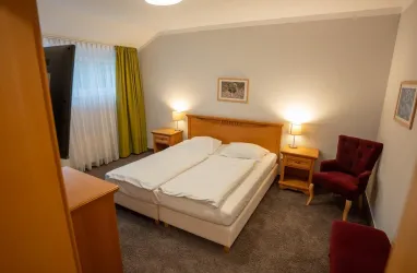 Doppelzimmer Standart mit einem Doppelbett, einem Schrank und einem Schreibtisch