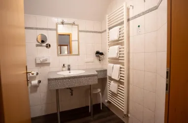 Waschtisch mit Spiegel, Fön und beheizbarer Handtuchhalter an der Wand