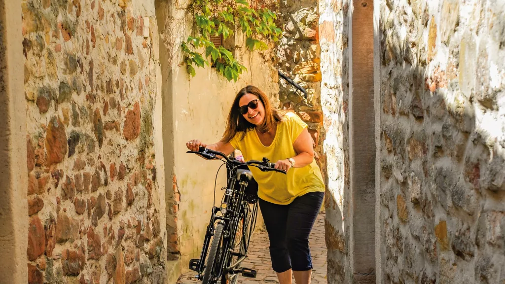 Frau mit Fahrrad in Freinsheimer Gasse