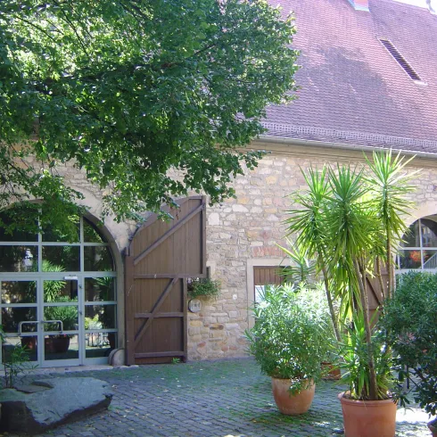 Bürgersaal Von-Busch-Hof mit Eingangstür und begrüntem  Innenhof