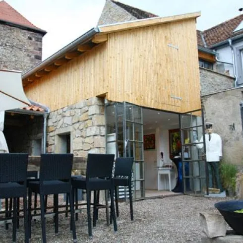 Eingangsbereich der 0815 Wein-Lounge mit Bestuhlung und der hist. Stadtmauer im Hintergrund.