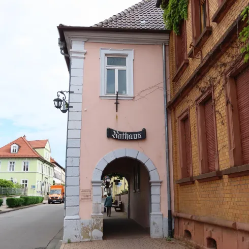 <p>Historisches Rathaus in Weisenheim am Sand. Seitenansicht mit Durchgang, Fenster und Sschriftzug über dem Torbogen.